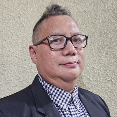 A warm professional portrait of Dr. Norman Hassan.